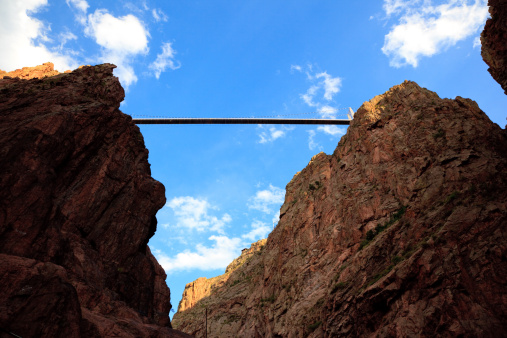 Royal Gorge Bridge is the highest bridge in the world. From the beneath, the bridge is high up far away under blue sky.