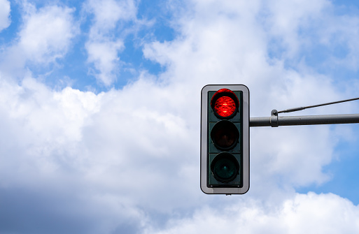 Red light of traffic light against cloudy sky, Berlin Potsdamer Platz