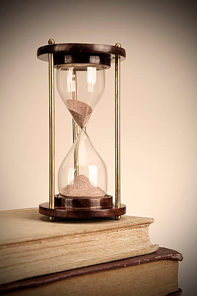 Sandglass is on top of old books.