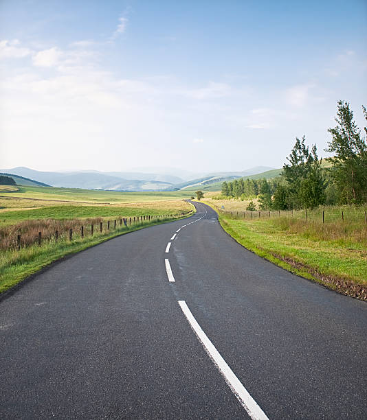 Winding Country Road A curving, quiet road in the rolling countryside of the Scottish Borders. country road stock pictures, royalty-free photos & images