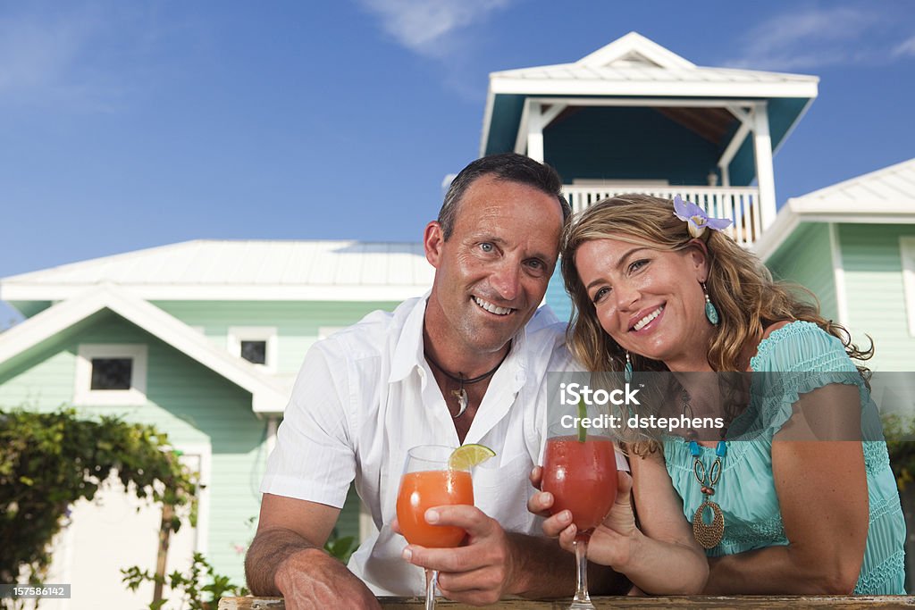 Sorridente coppia adulta con bevande - Foto stock royalty-free di Casa