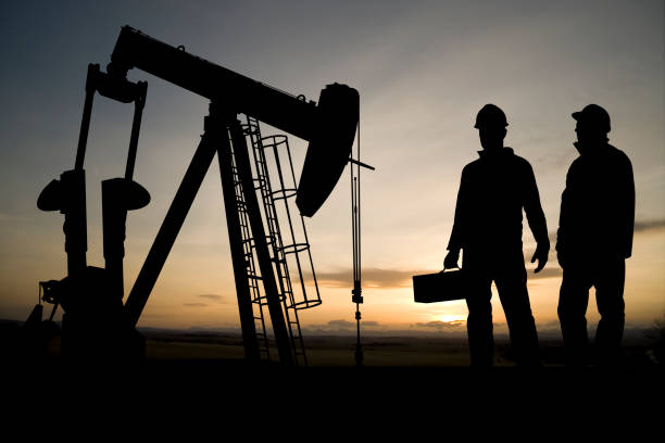 istock Two Workers and an Oil Derrick 157586203
