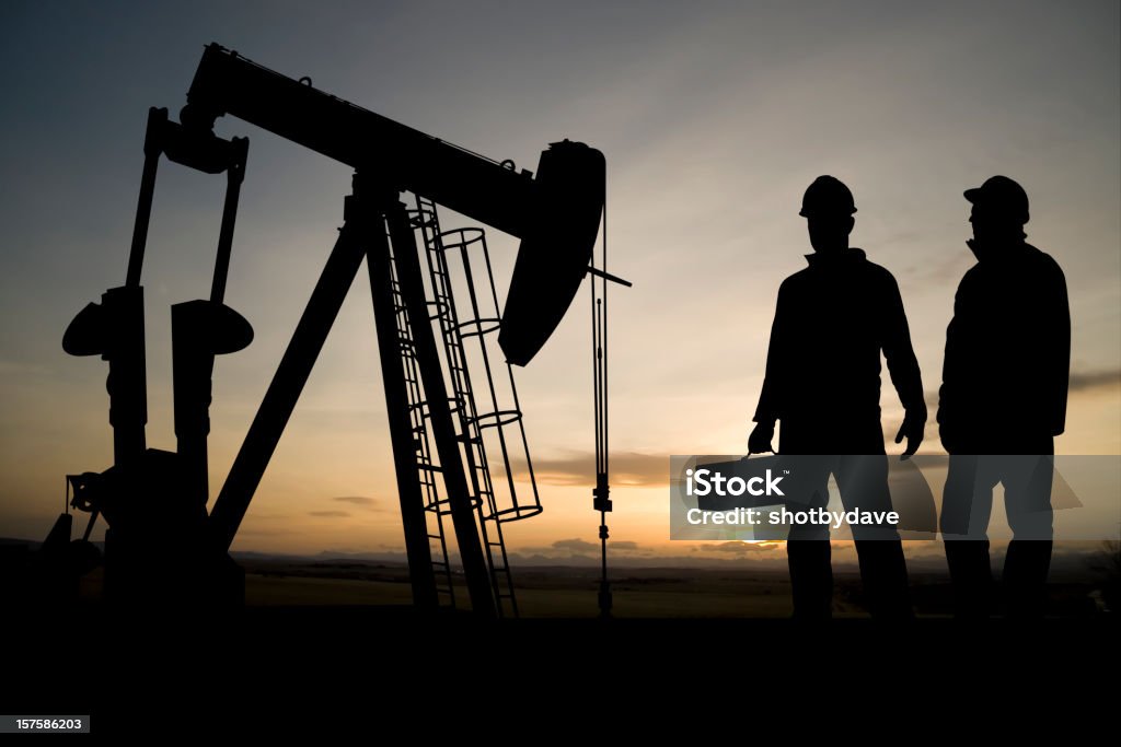 Two Workers and an Oil Derrick  Repairing Stock Photo