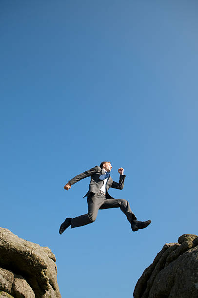 istock Brave Businessman Jumping between Rocks Blue Sky 157586231