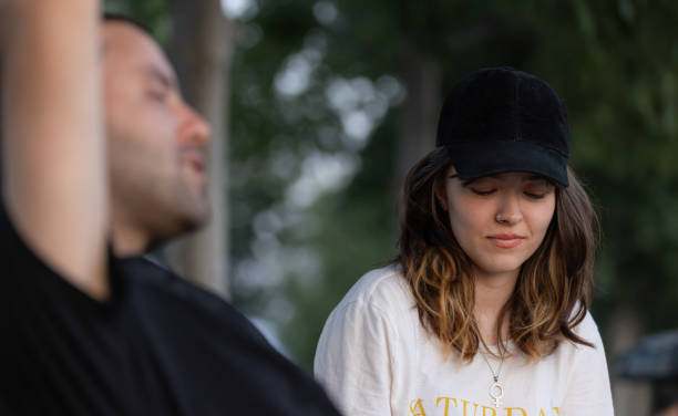 istock Young couple is sitting on the public park bench and talking each other. 1575863286