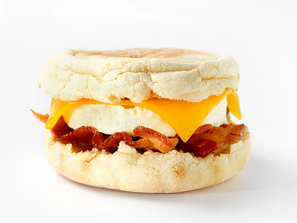muffin breakfast sandwich - cheese focus on foreground on top of portion stock-fotos und bilder