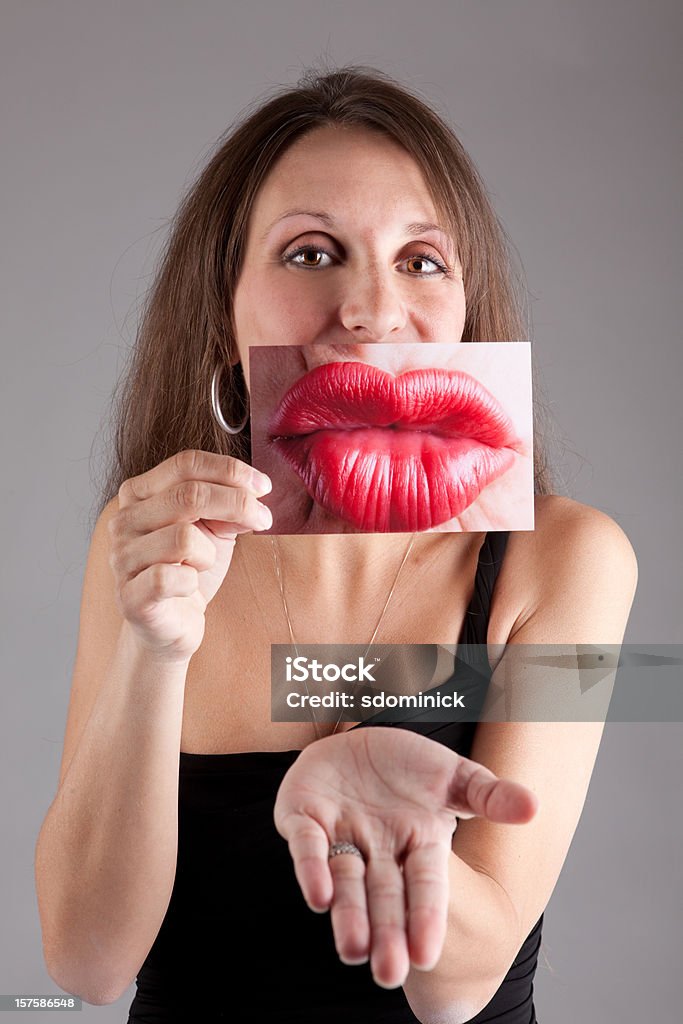 Kobieta trzyma zdjęcie usta - Zbiór zdjęć royalty-free (25-29 lat)
