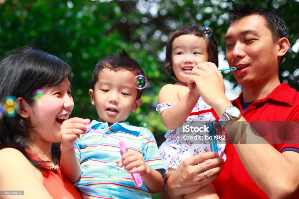 young family playing bubble in the garden 30-39 Years Stock Photo