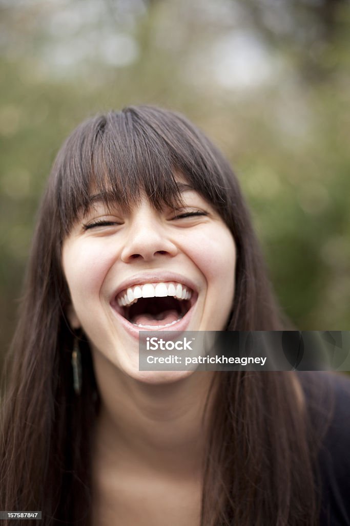 Dark haired woman with bangs is laughing A pretty laughing young woman Adult Stock Photo