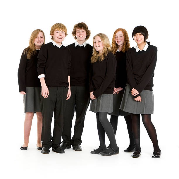 Early teen students taking a group picture Bright smiles and eye contact for the camera from a group of 13 year-old children in generic school uniform. cute 15 year old girls stock pictures, royalty-free photos & images