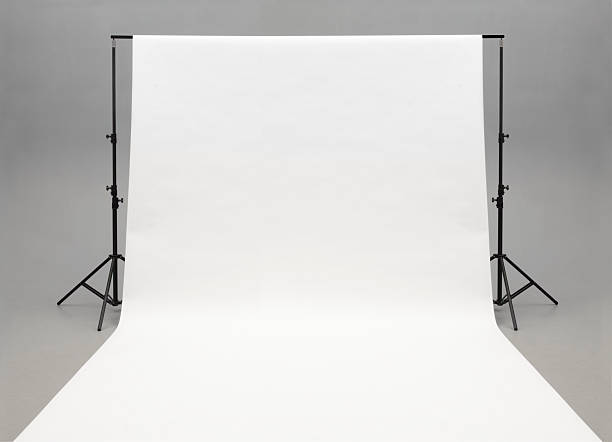 Seamless white background paper hanging on stands-isolated on grey White seamless paper suspended from a bar supported by two black light stands. White paper pulled out toward the camera and runs out of the foreground. Seamless gray background.see #12761288 for red paper.http://www.garyalvis.com/images/conceptsIdeas.jpg photo shoot stock pictures, royalty-free photos & images