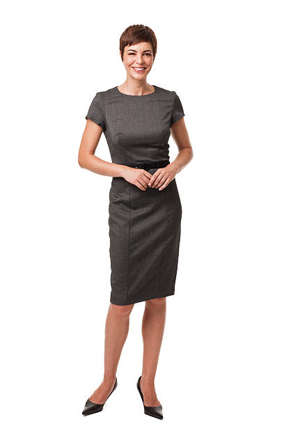 Businesswoman in Gray Dress Isolated on White Short haired businesswoman wearing a gray, belted dress. She is standing with her fingers clasped and is isolated on a white background. Vertical shot. whole stock pictures, royalty-free photos & images
