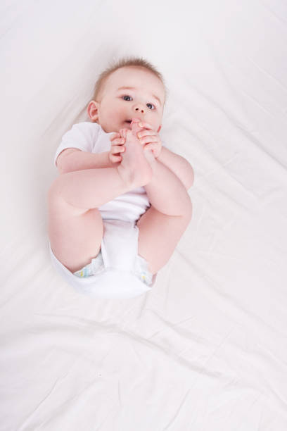 istock Baby - feet in mouth 157588527