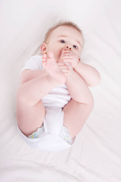 istock Baby with feet in his mouth 157588531