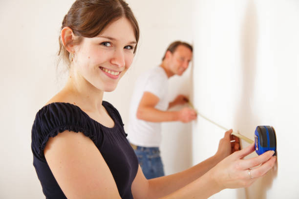 young couple measuring the rooms in their new apartment young couple measuring the rooms in their new apartment measuring a room stock pictures, royalty-free photos & images