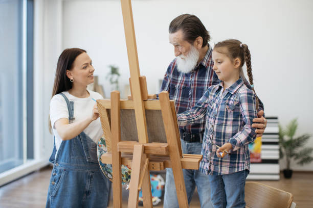 istock Creative family drawing on paper at easel in home studio 1575889054