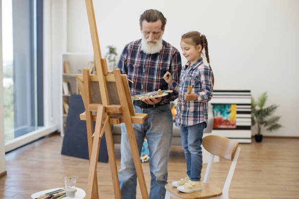istock Male with grandchild applying paints on art work at home 1575889100