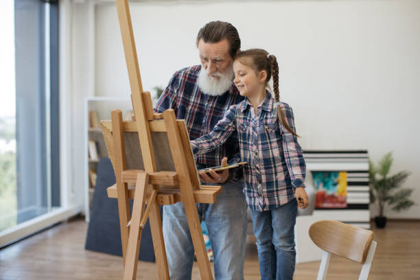 istock Child enjoying art making with grandpa in home studio 1575889333