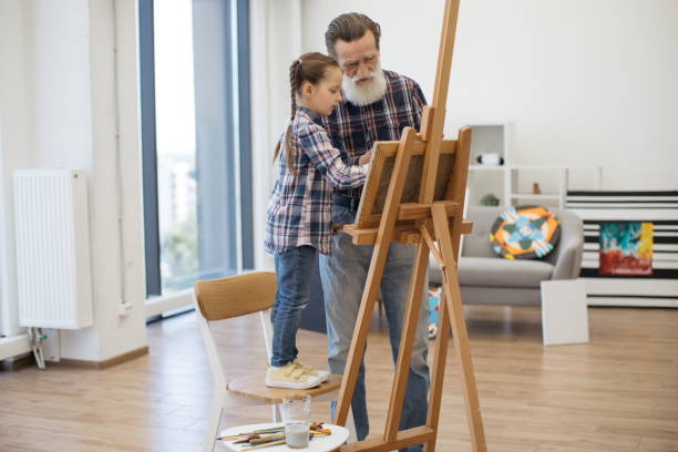 istock Child enjoying art making with grandpa in home studio 1575889601