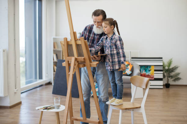 istock Child enjoying art making with grandpa in home studio 1575889628