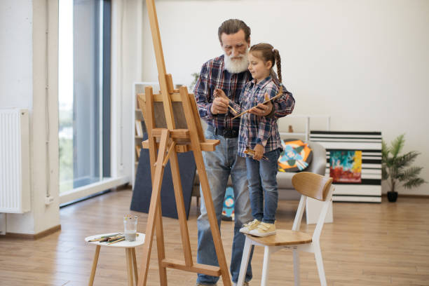 istock Child enjoying art making with grandpa in home studio 1575889639
