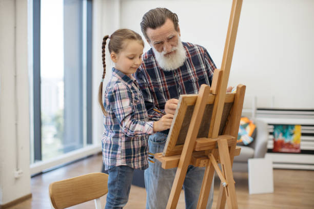 istock Child enjoying art making with grandpa in home studio 1575889643