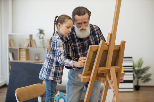istock Grandpa teaching color combination rules to child in studio 1575889667