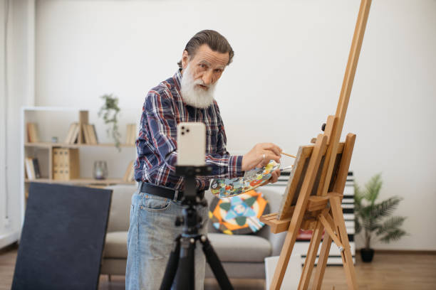 istock Pensioner shooting video content about art indoors 1575890272