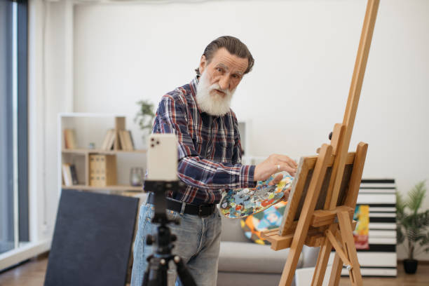 istock Senior painter making video recording on white smartphone 1575890292