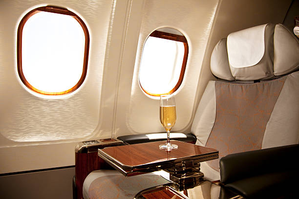 sièges de la classe affaires avec champagne servi - business travel photos et images de collection