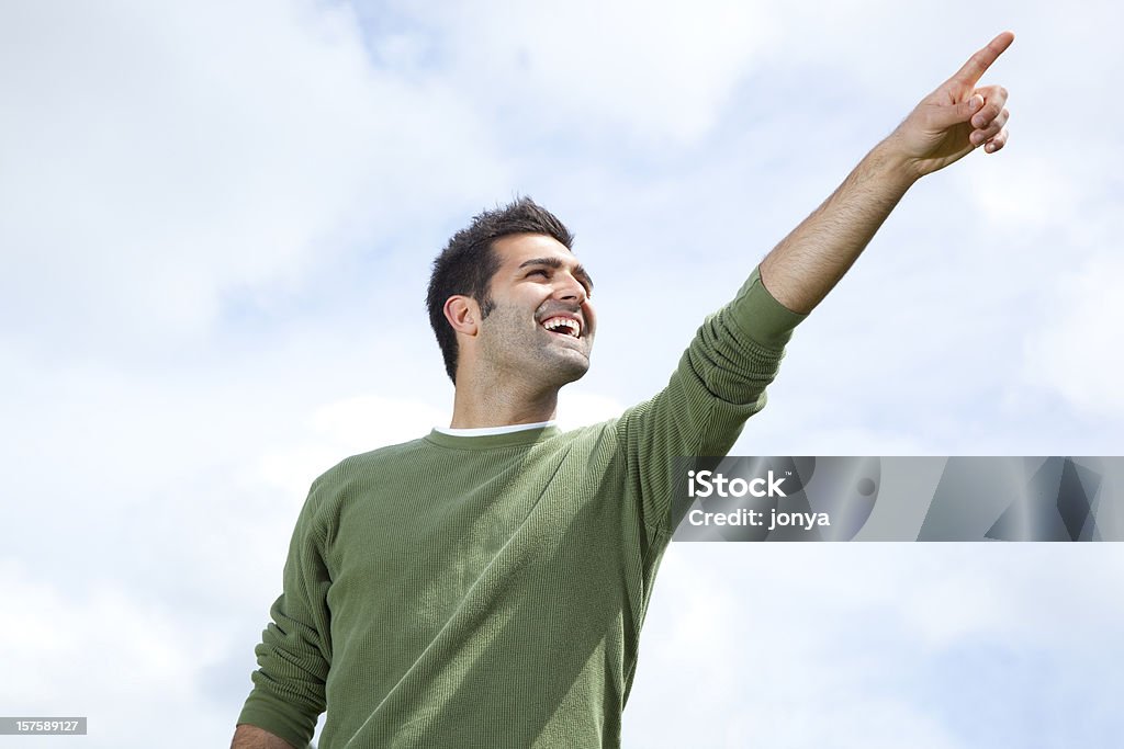 Homem sorridente apontando para o céu aberto - Foto de stock de Apontar - Sinal Manual royalty-free