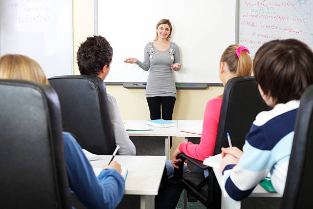 élèves du secondaire assis dans une salle de classe à la leçon. - studygroup photos et images de collection