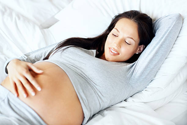giovane donna incinta guardando il suo ventre - 20s adult camera caucasian foto e immagini stock