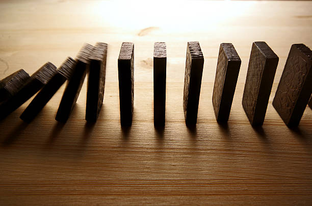Falling row of dominoes on wooden surfaces Photo of falling domino in motion. domino photos stock pictures, royalty-free photos & images