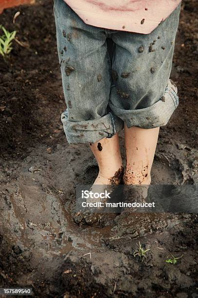 Feet Of Little Boy When Water And Soil Makes Mud Stock Photo - Download Image Now - Mud, Child, Mixing