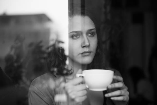 istock Woman drinking tea looking outside the window 157589811