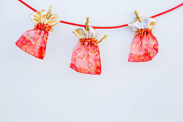 Three red transparent pouches for present or Christmas on a red rope on white background isolated