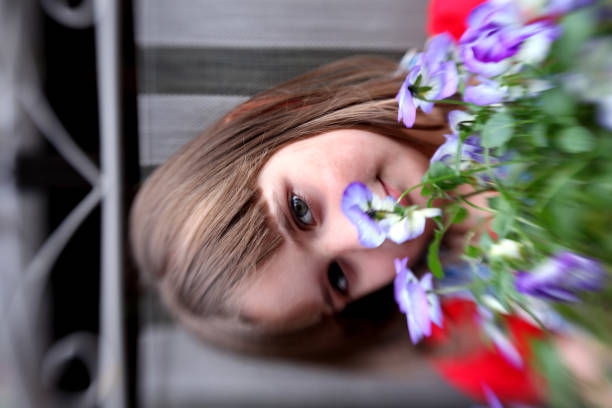 Little girl holding pansies. Lensbaby image that creates Shallow DOF and blur. Focus on eye and hair.