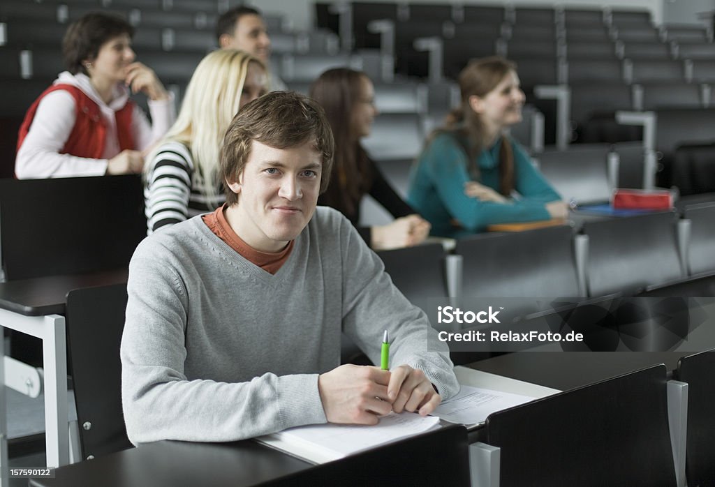 Ritratto di uomo studente con gli amici in Aula universitaria - Foto stock royalty-free di Gruppo di persone