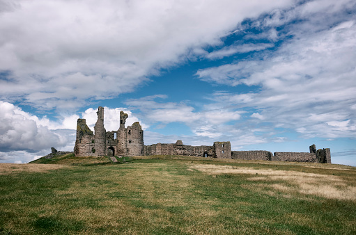 Craster, United Kingdom- July 12, 2023: Photograph of Dunstanburgh Castle on the North Sea coast of Northumberland, England. The castle was build in the 14th Century.