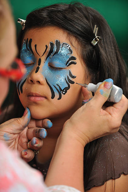 女性は彼女の顔に塗り移動 - art child painting student ストックフォトと画像
