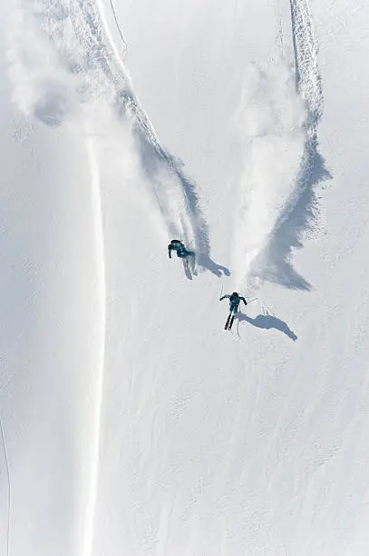 Photo of Aerial view of two skiers skiing downhill in powder snow