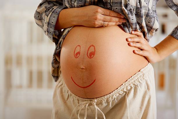 istock Pregnant belly with smiley face 157590532