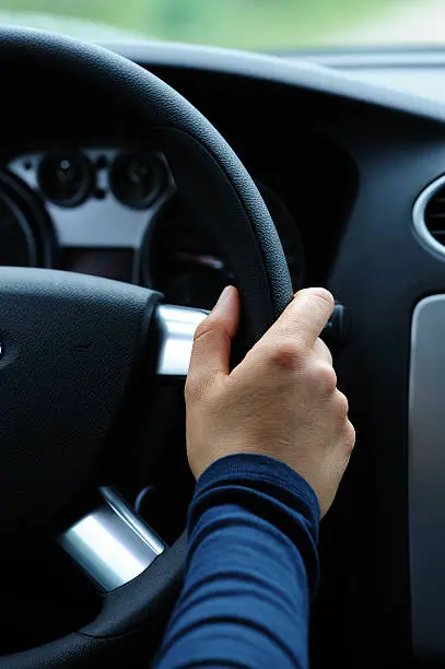 Photo of A hand holding the steering wheel