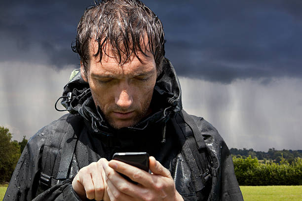 chuva embebido sapatos de consulta gps smartphone com ecrã táctil - rain drenched men wet imagens e fotografias de stock