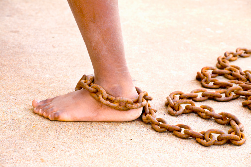 A dirty leg with a rusty chain.