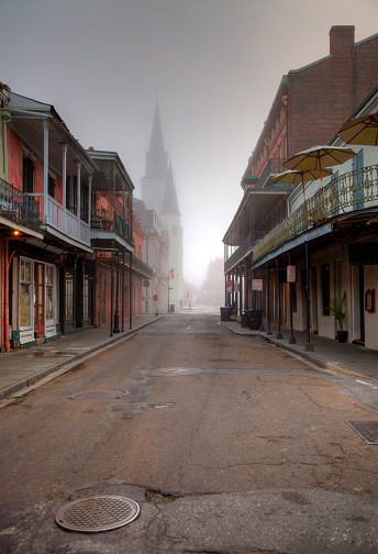 City street leading to the Saint Louis Cathedral in the French Quarter on a foggy morning. The French Quarter, also known as the Vieux Carré, is the oldest neighborhood in the city of New Orleans. New Orleans is known for its famous Creole food, unique architecture, music, nearby swamps and plantations and all-around mysticism