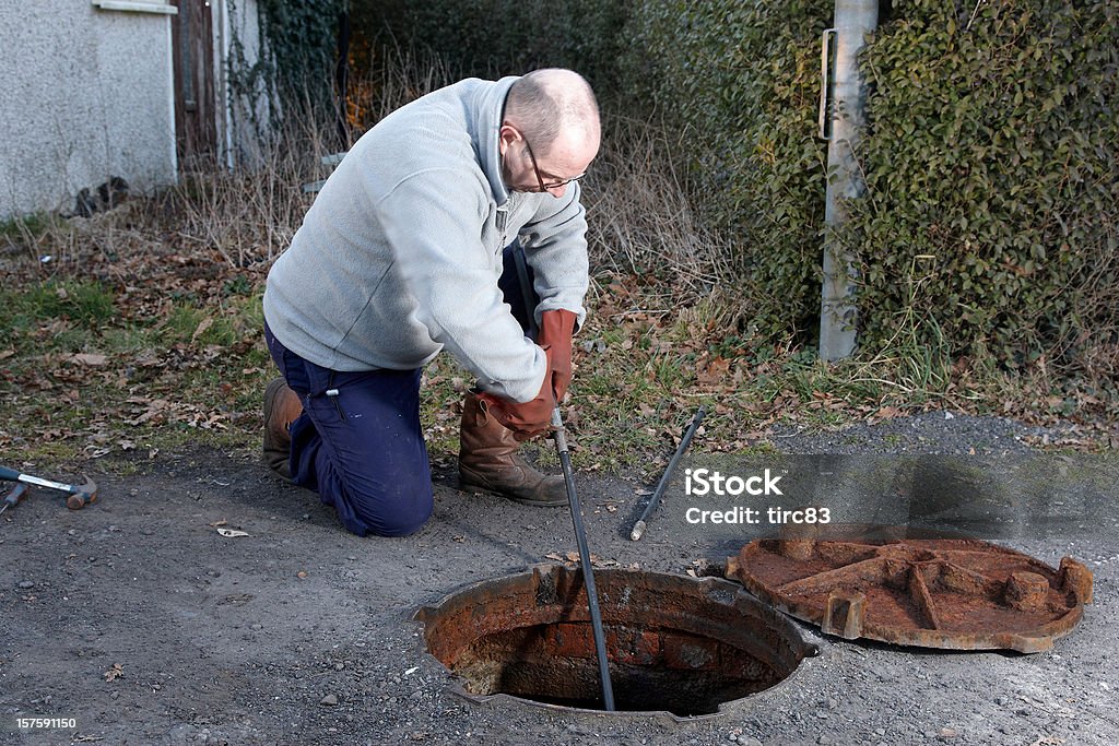 Homem limpeza dos esgotos - Foto de stock de Tanque séptico royalty-free