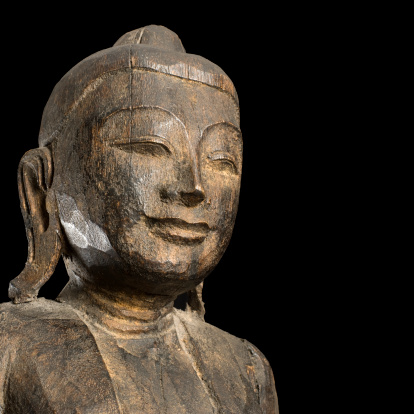 Ancient wooden Buddhist sculpture, studio shot on black background. Further choices below:
