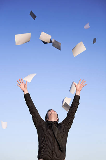istock Young businessman throwing paper in air, blue sky 157591233